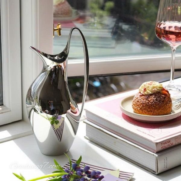 Bình nước Georg Jensen Henning Koppel 1.2 Lít được làm bằng thép không gỉ và gây ấn tượng với hình dáng cong mềm mại.