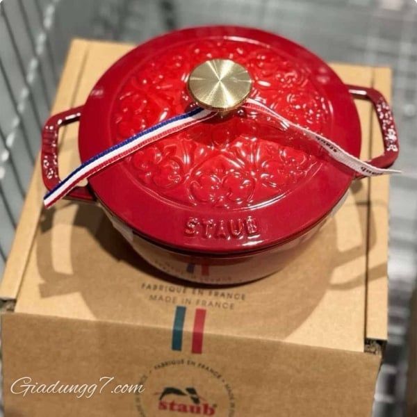 Nồi gang Staub La Marmite Lys 16cm 1.1L màu đỏ - Hình vẽ hoa loa kèn, Núm vặn bằng đồng thau.  Thiết kế nắp hoa văn Fleur de Lys sang trọng, tinh tế.