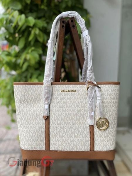 Túi xách Michael Kors Jet Set Travel Large Logo Tote Bag Được chế tác từ vải bạt có in chữ ký với viền da, nó mở ra không gian nội thất rộng rãi với nhiều không gian để lưu trữ