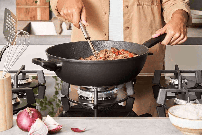 Chảo sâu lòng Fissler đang được sử dụng để xào nhanh các món ăn trên lửa lớn