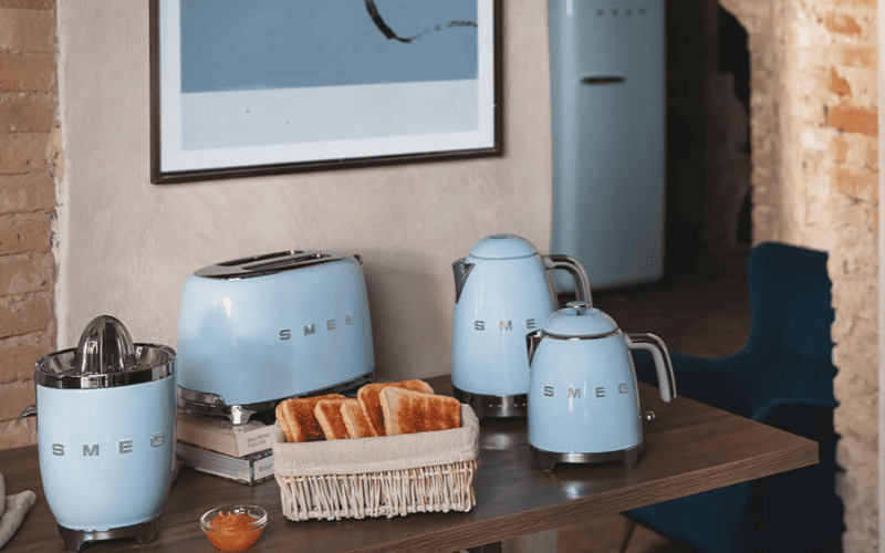 Máy pha cà phê SMEG đặt trong gian bếp hiện đại với tông xanh pastel