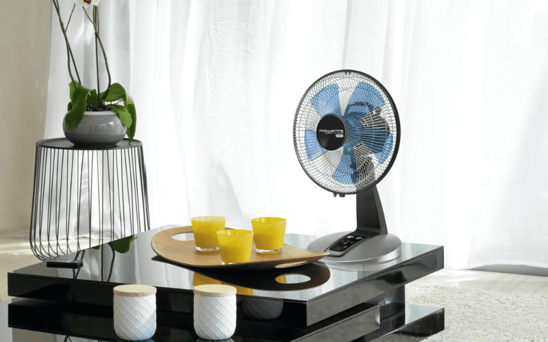 Quạt bàn Rowenta Turbo Silence nhỏ gọn được đặt trên bàn phòng khách, mang lại luồng gió mát mẻ, tập trung