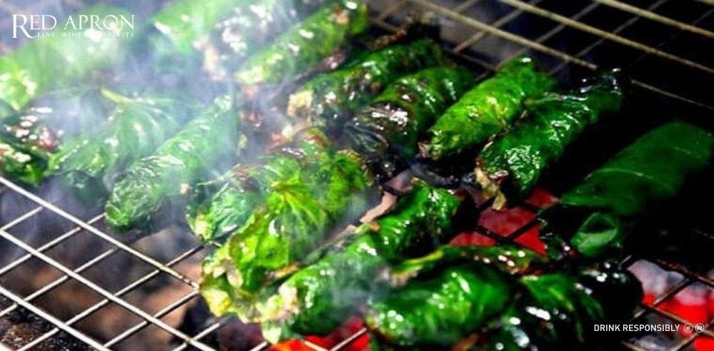 Mâm món Việt gồm thịt nướng lá lốt, bò lúc lắc, cà ri gà, ăn kèm rượu vang Negroamaro.
