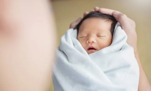 Vì sao cần dùng khăn quấn người cho bé khi ngủ?