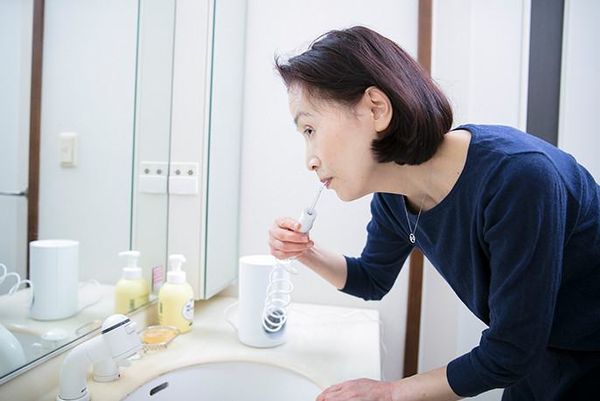 Khách chăm sóc răng miệng bằng máy tăm nước Panasonic EW1611