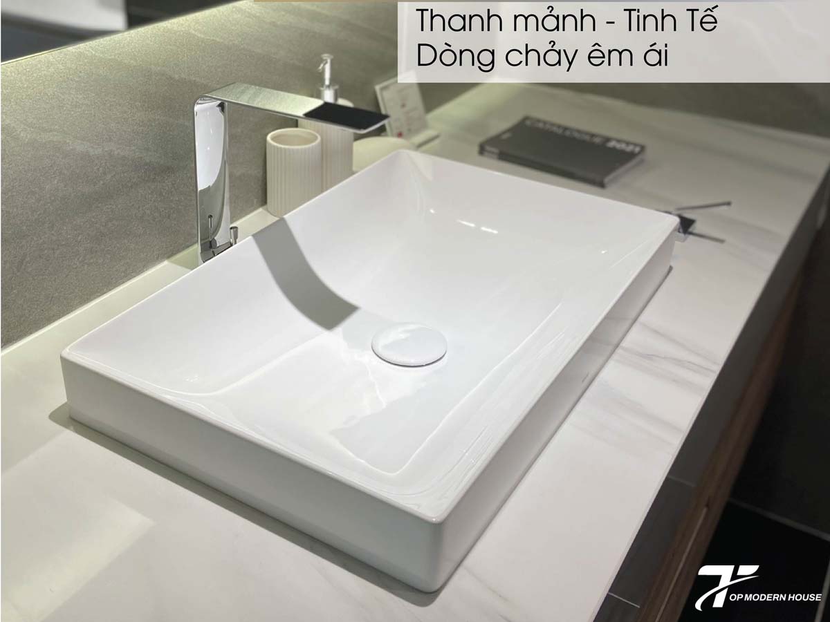Chậu rửa mặt hình chữ nhật mang kiểu dáng hiện đại, góc cạnh rõ ràng, tạo cảm giác gọn gàng và sang trọng cho phòng tắm.