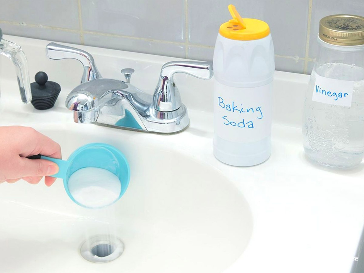 Baking soda kết hợp giấm tạo phản ứng sủi giúp tẩy sạch cặn ố và khử mùi hiệu quả cho chậu rửa mặt.