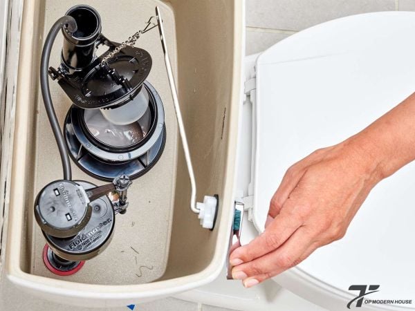 Tháo kiểm tra và vệ sinh cần gạt, thay thế nếu bị gãy hoặc kẹt để đảm bảo cơ chế xả hoạt động trơn tru.