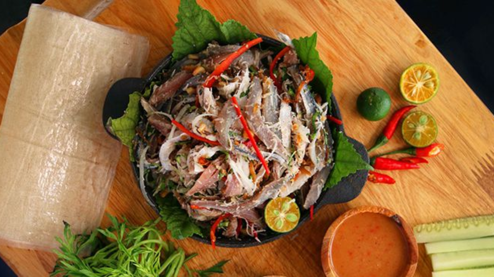 thưởng thức gỏi cá trích cuốn bánh tráng và rau sống