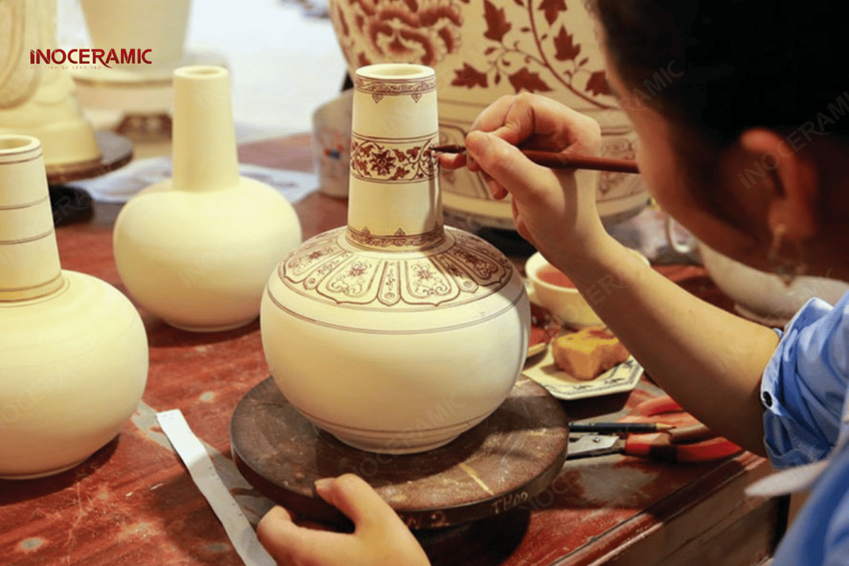 Nghệ nhân đang vẽ tay hoa văn truyền thống trên sản phẩm gốm