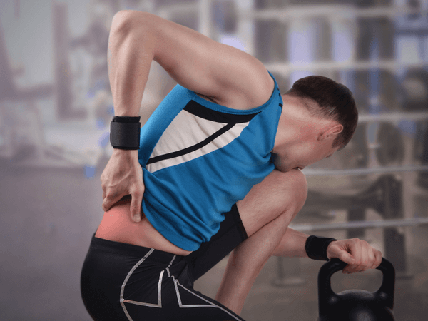 Người tập gym đang căng cơ vùng thắt lưng sau khi tập luyện