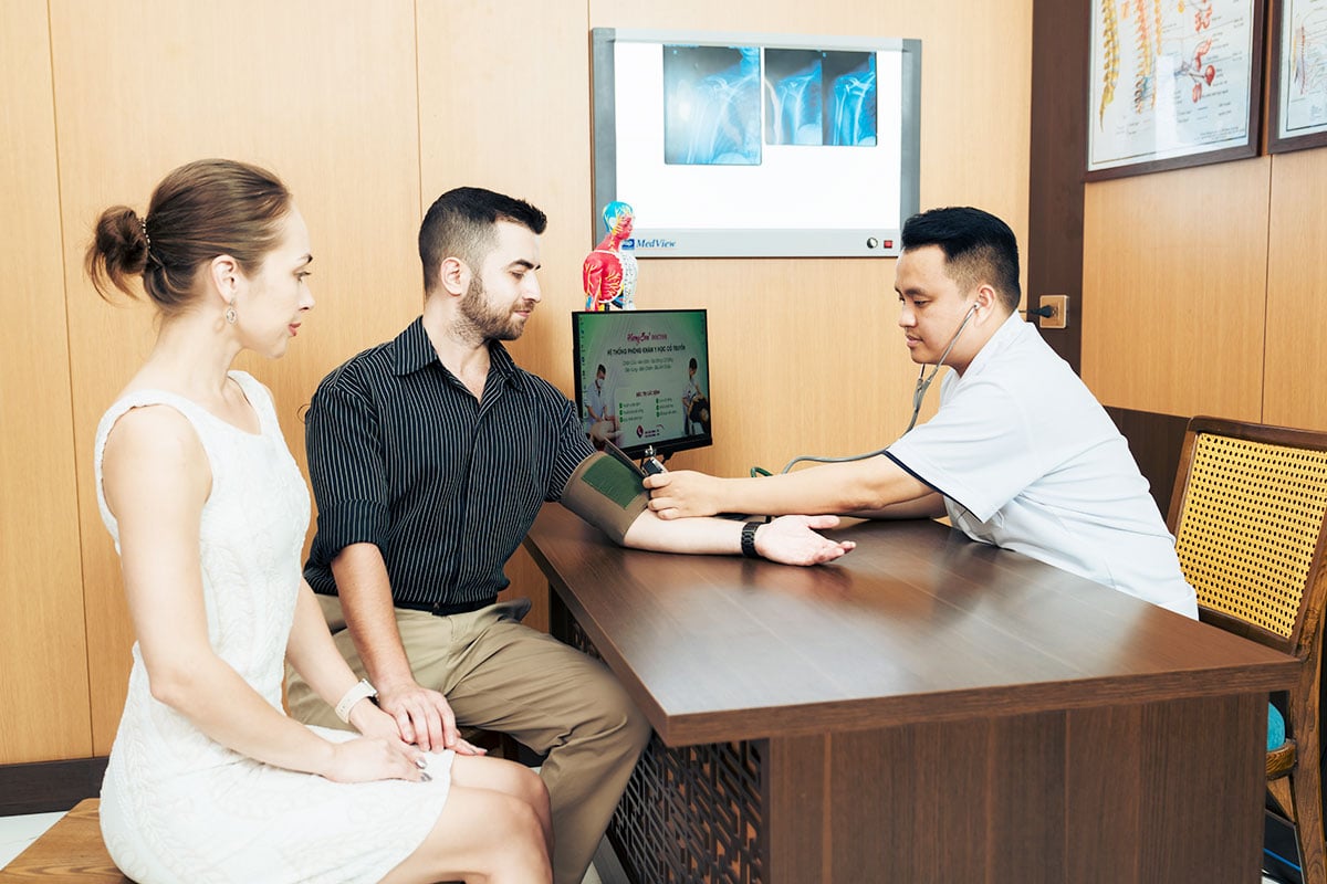 Traditional Medicine doctor consulting with a client before treatment in HCMC