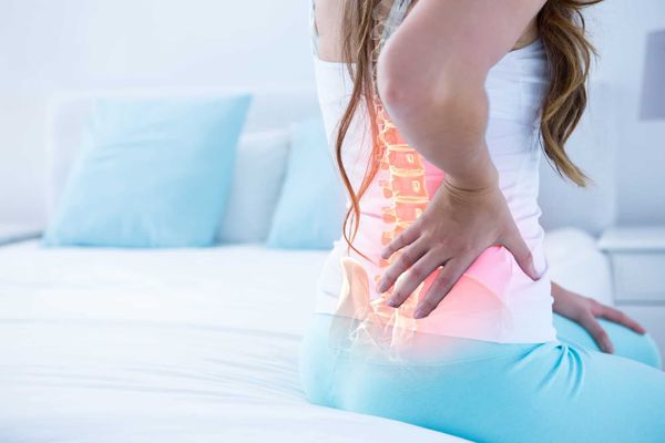 Người phụ nữ ôm lưng phải, biểu hiện cơn đau âm ỉ