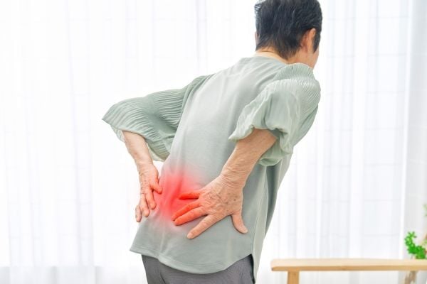 Người lớn tuổi cầm lưng, thể hiện cảm giác đau nhức toàn thân