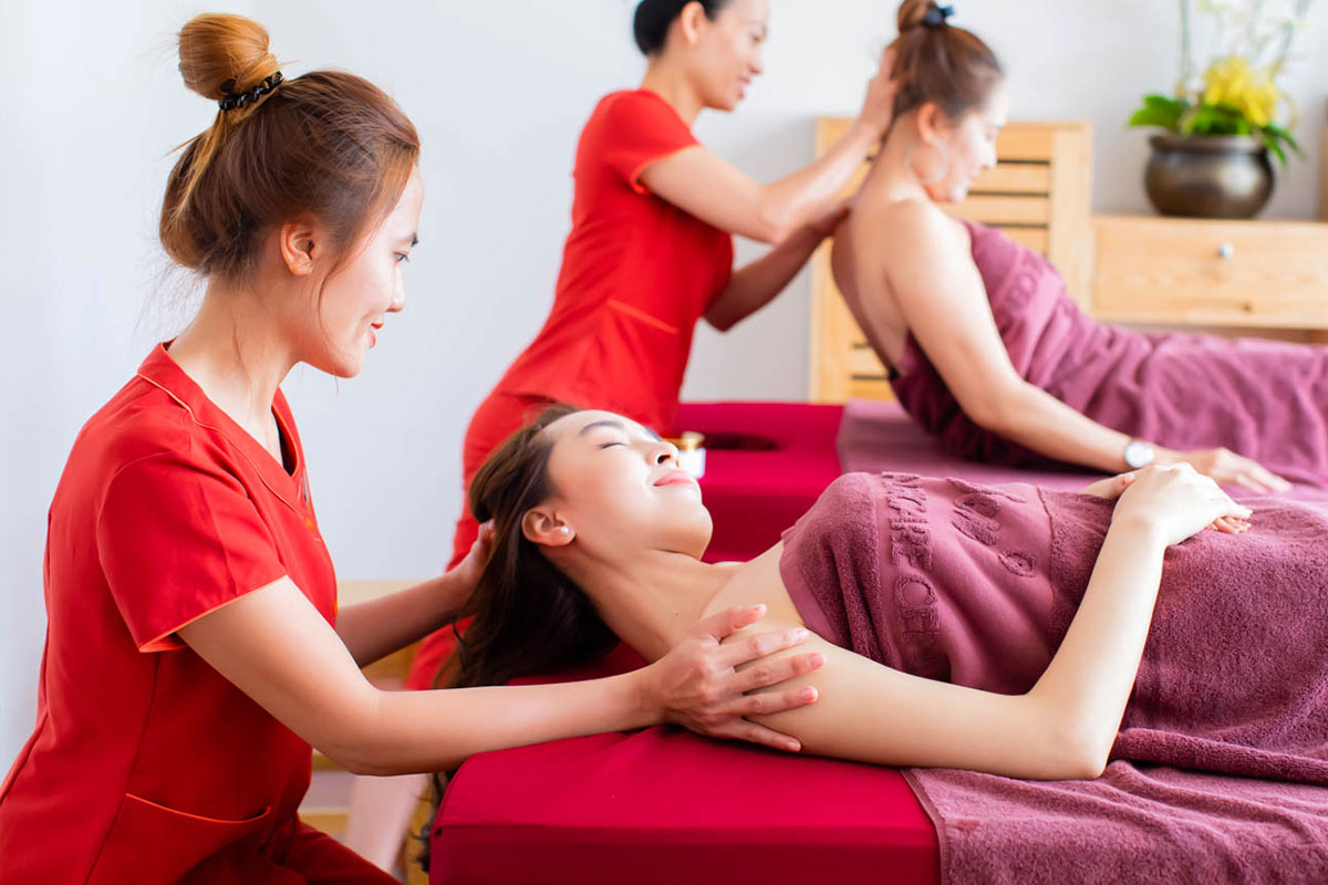 Kỹ thuật viên thực hiện massage trị liệu bấm huyệt giúp giảm đau cơ cho người làm việc văn phòng