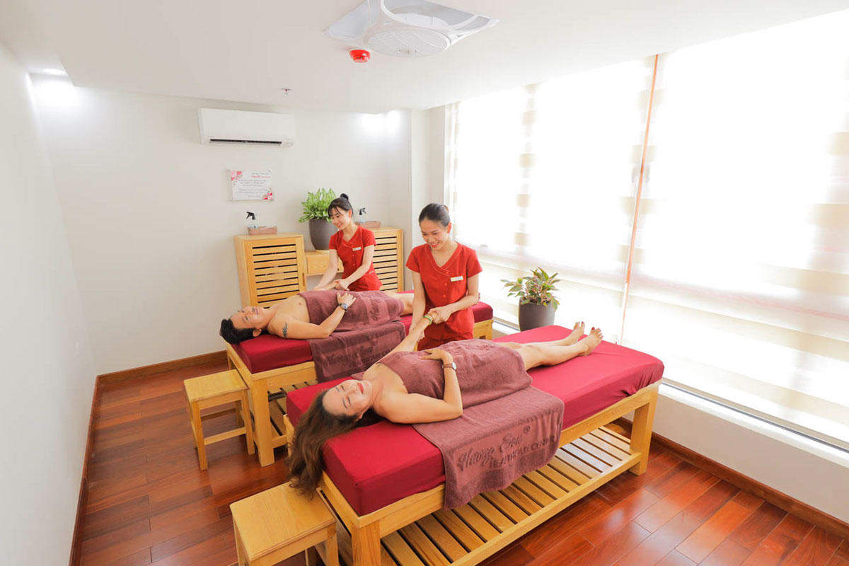 Kỹ thuật viên đang trị liệu bấm huyệt giúp khách hàng thư giãn hệ thần kinh