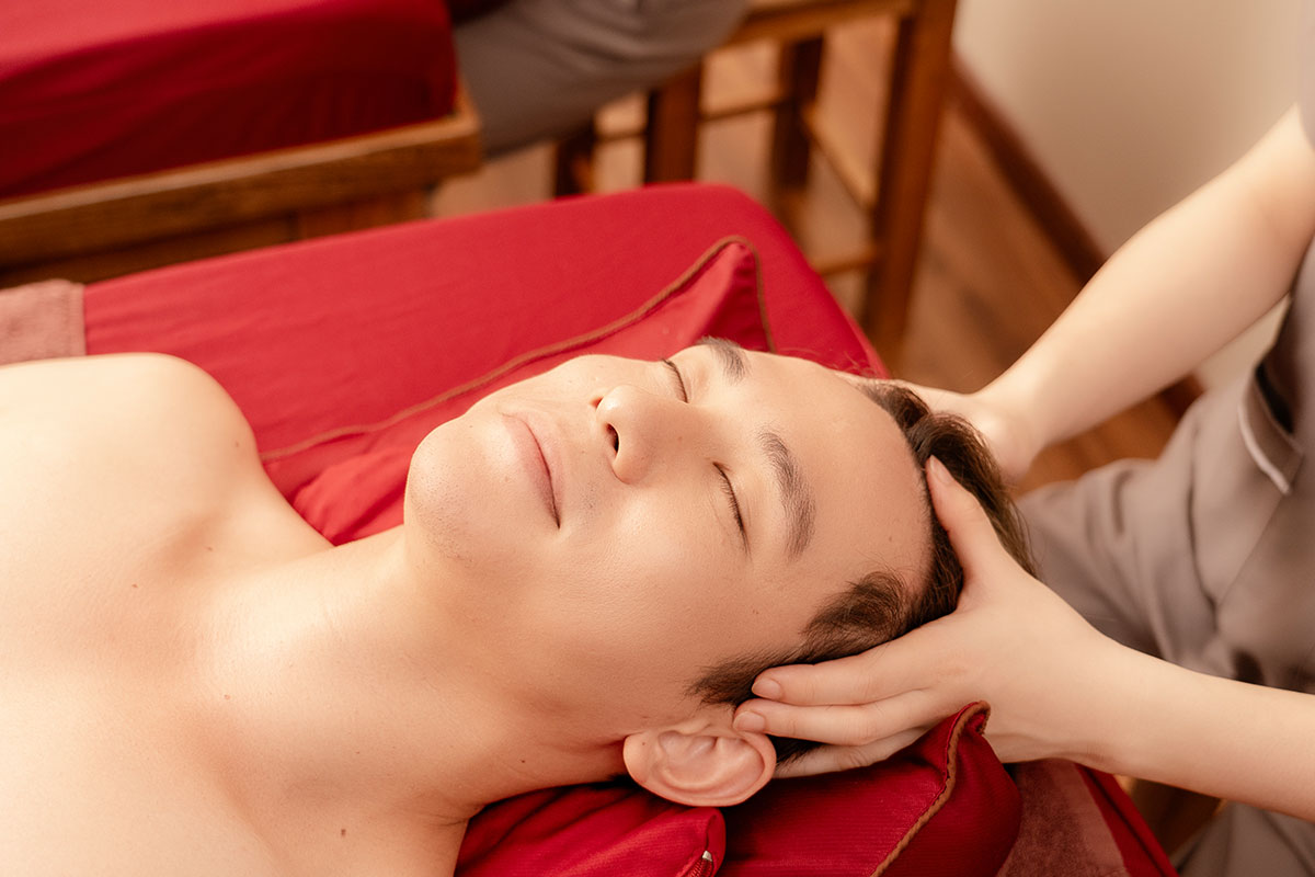 Kỹ thuật viên đang massage trị liệu cho khách để làm mềm mô cơ, giảm đau vùng lưng