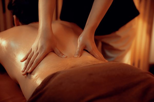 Kỹ thuật viên đang thực hiện bấm huyệt vùng lưng cho bệnh nhân thoát vị