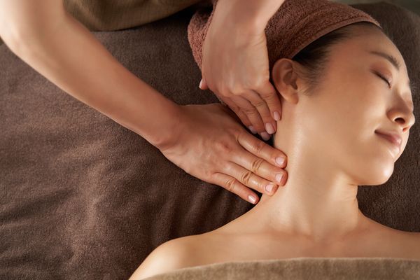 Kỹ thuật viên đang xoa bóp bấm huyệt vùng cổ – vai – gáy cho khách hàng