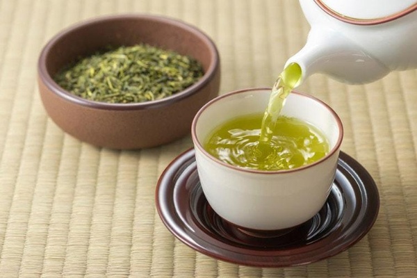Trà xanh có chứa vitamin và caffeine giúp tiêu hóa nhanh, giảm tích tụ mỡ thừa. Trà đang được rót ra ly