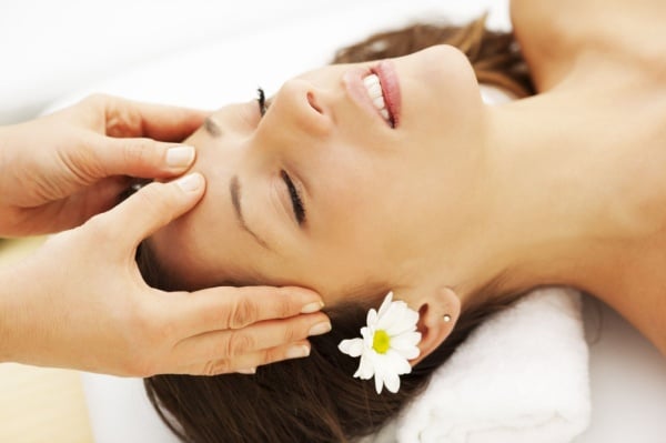 Người phụ nữ đang thực hiện bấm huyệt trẻ hóa gương mặt