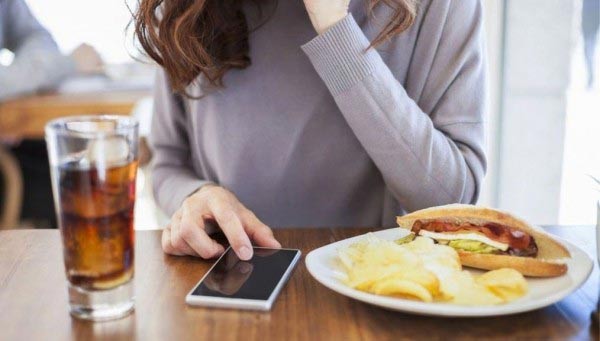 Vừa ăn vừa dùng điện thoại gây béo bụng Vừa ăn vừa dùng điện thoại gây béo bụng